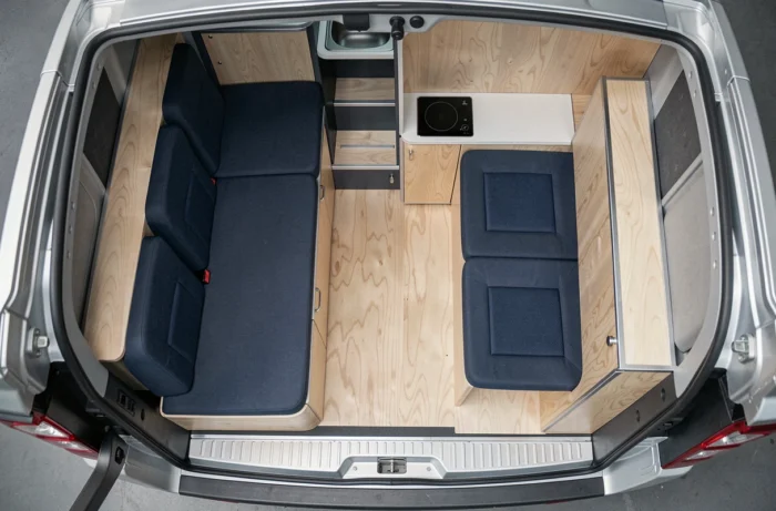 Vue aérienne de l'intérieur d'un Trafic aménagé en espace de vie compact avec cuisine et rangements modulables